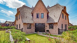 A large brick house with a steeply pitched roof and a symmetrical facade. - Herzlich Willkommen im Ferienhaus Trauminsel (List)