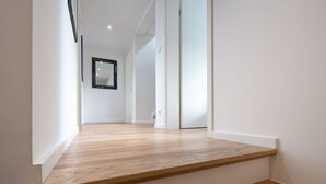 Ein moderner Flur mit Holzboden und weißen Wänden.