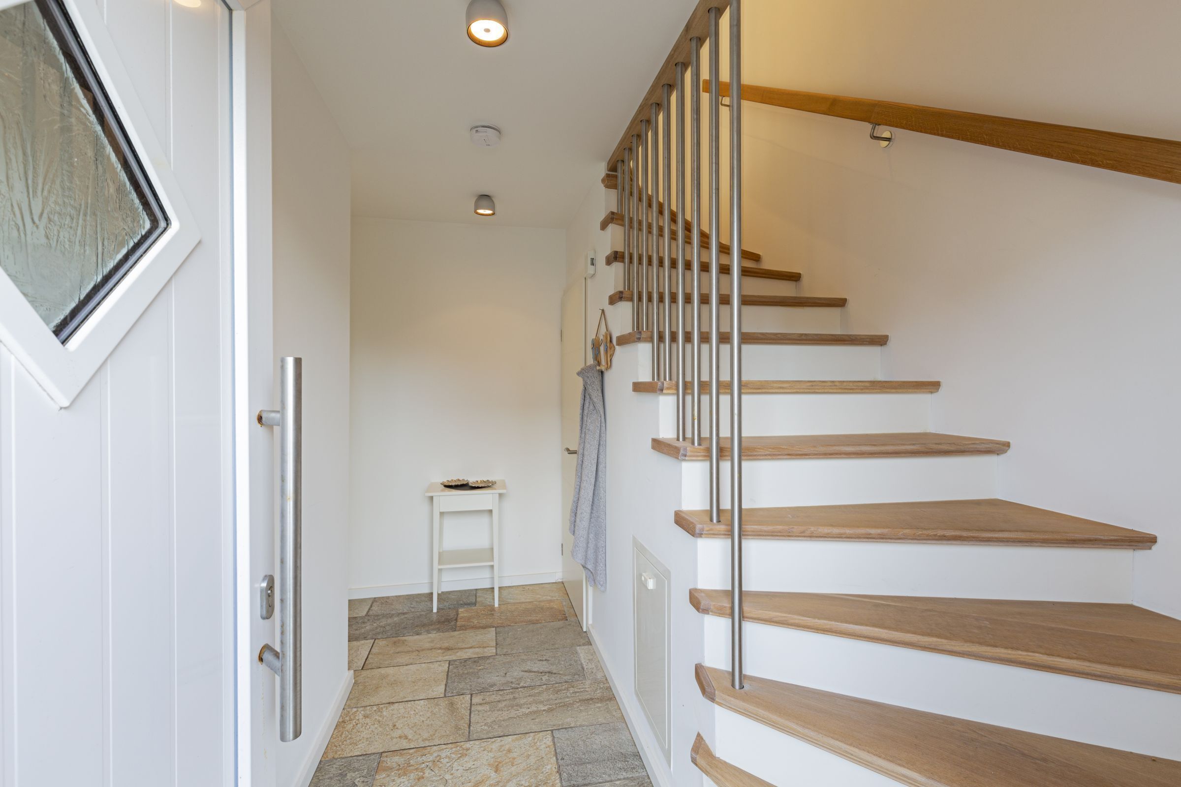 Eine Treppe mit Holzdielen und Metallgeländern, die zu einer oberen Etage führt.