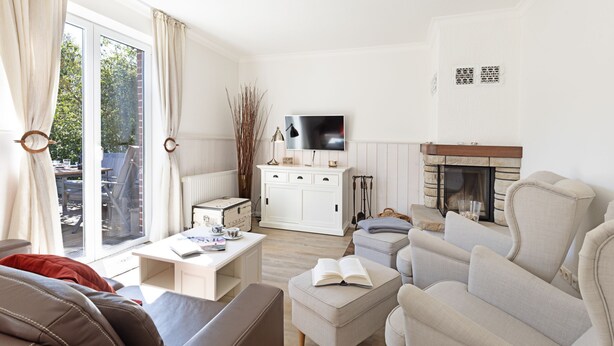 A modern living room with a sofa, armchairs, a coffee table, and a fireplace.