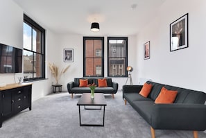 A modern living room with a sofa, coffee table, and a TV. - Apt 3, 15 West Street (Hereford)