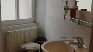 A bathroom with a toilet, sink, and window. - Landgasthof Kirschgarten (Ingelheim am Rhein)