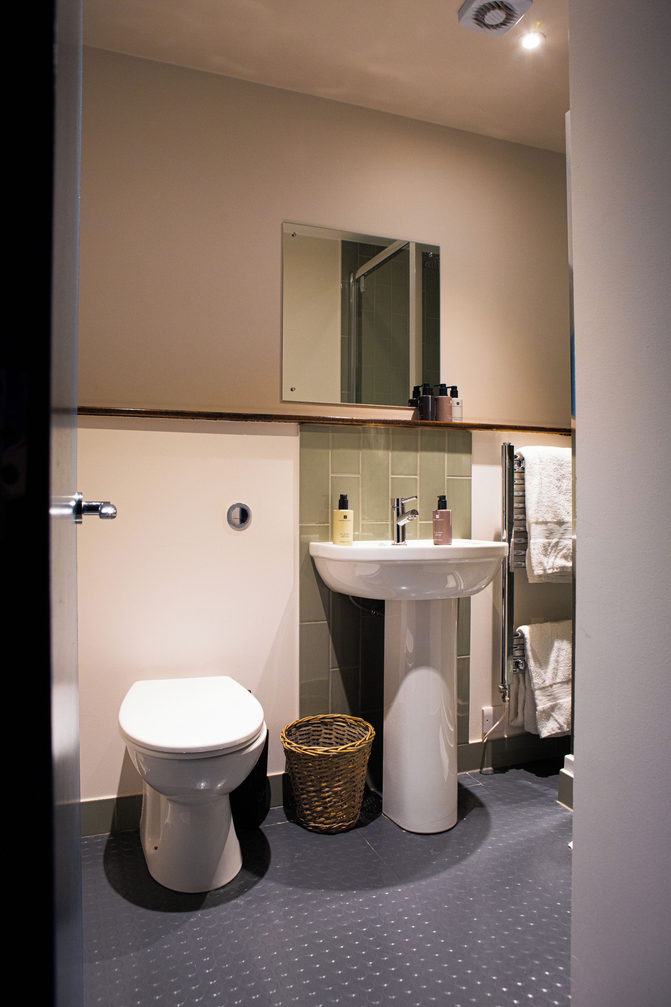 A modern bathroom with a toilet, sink, and shower.