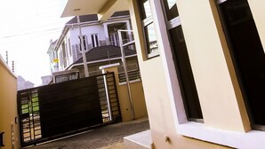 A modern two-story building with a flat roof, a central air conditioning unit, and a gated entrance. - Stunning 3-bed House in Lagos (Lagos)