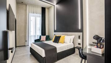 Una moderna camera d'albergo con un letto grande, una scrivania con una sedia, una TV a schermo piatto e una finestra con tende.