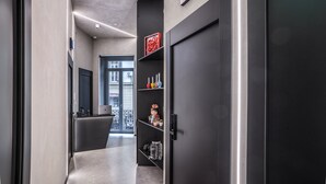 A modern hallway with a dark door, a neon sign, and a shelf with decorative items. - Gallery Experience Napoli (Naples)