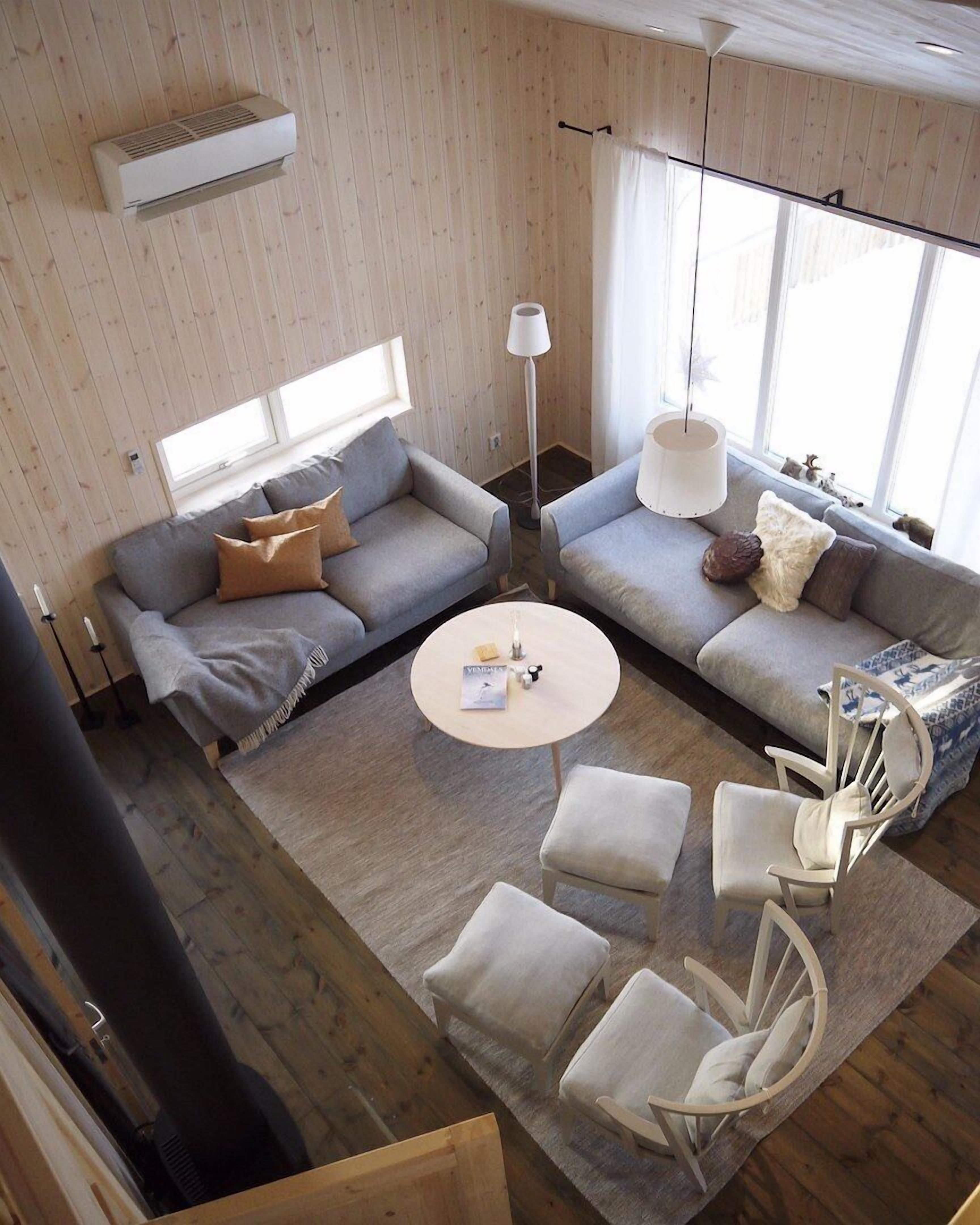 A modern living room with a sectional sofa, a round coffee table, and a white armchair.