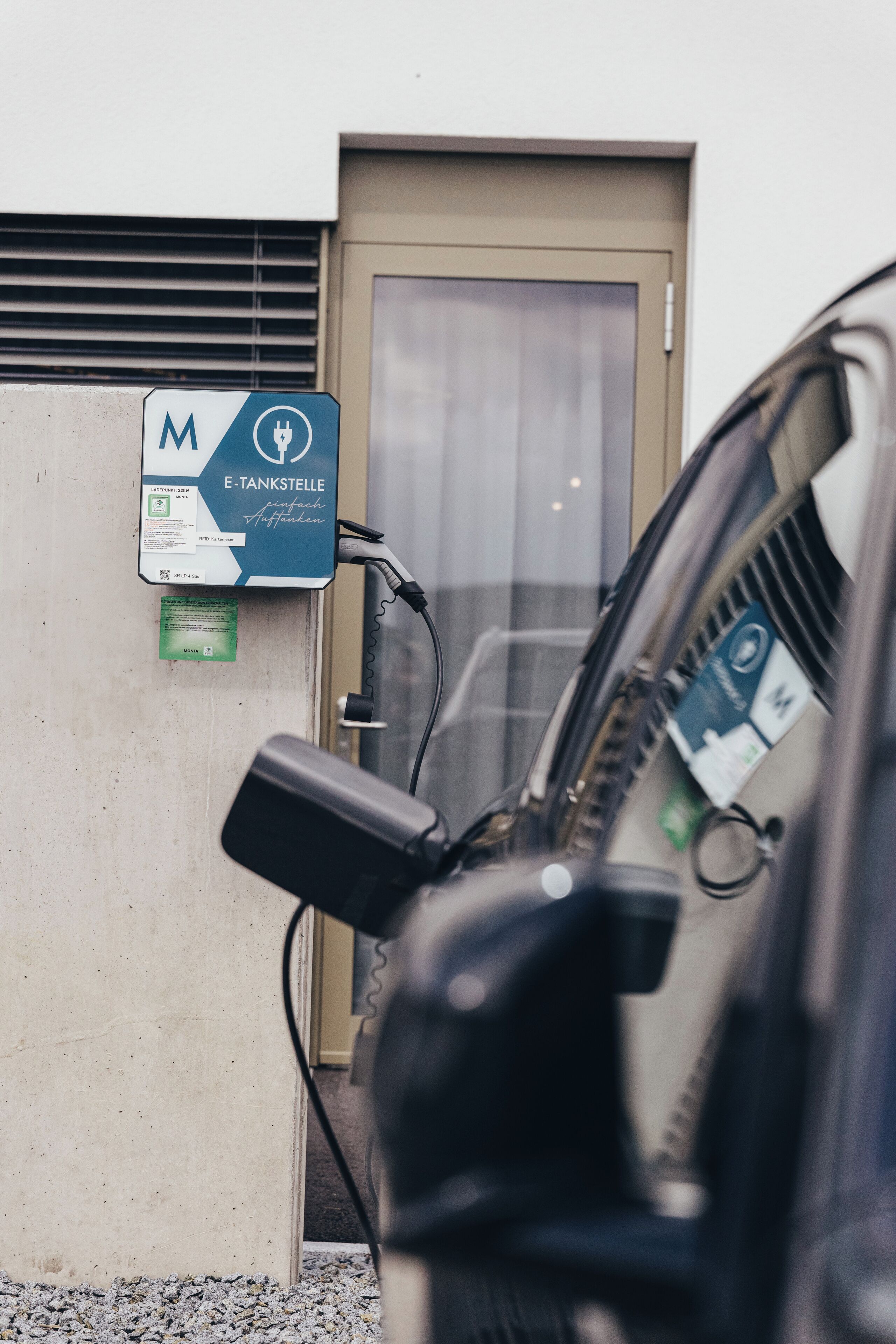 An electric vehicle charging station with a sign indicating it is a public charging point.