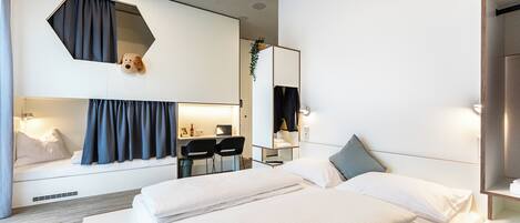 Una habitación de hotel moderna con una cama grande, un escritorio y un espejo.