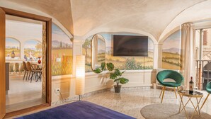 A room with a bed, a dining area with chairs and a table, a potted plant, and a large window with a view of a landscape. - Condotta House, a private space in the heart of historical center of Florence (Firenze)