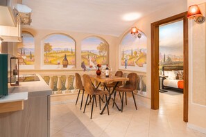 A dining area with a table and chairs, a view through arched windows, and a bed in the adjacent room. - Condotta House, a private space in the heart of historical center of Florence (Firenze)
