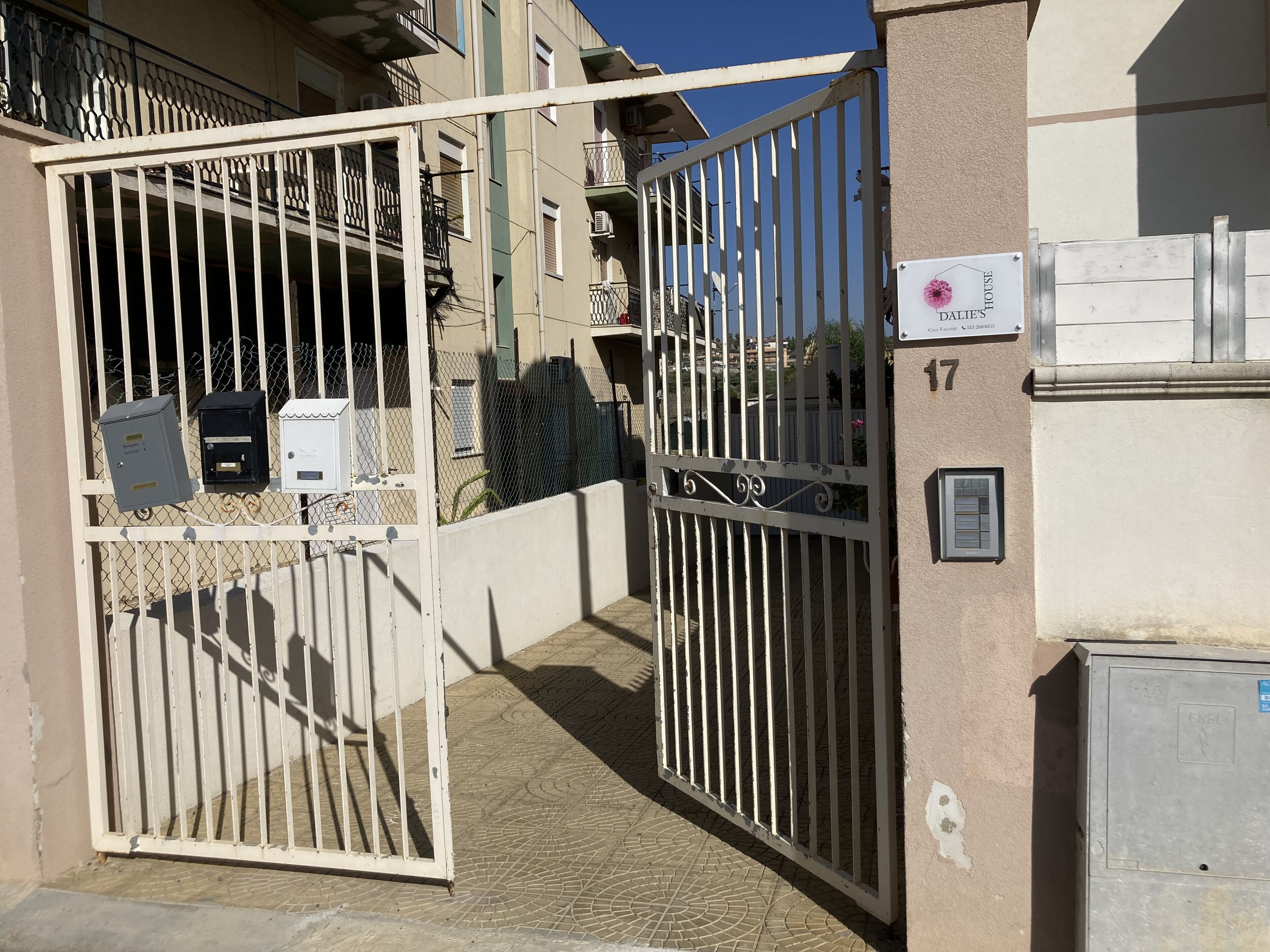 Una entrada con portón a un edificio, con un cartel que indica que es 'Dallie's House'.