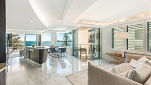 Una sala de estar moderna con un amplio ventanal, un comedor y una cocina con una isla central.