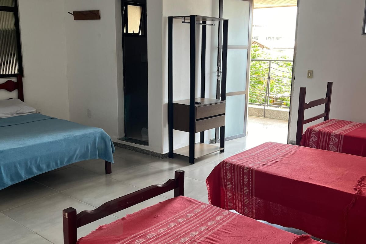 Una habitación de hotel con cama, escritorio, silla y balcón.