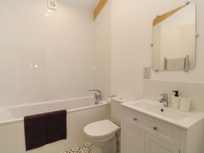 Une salle de bain moderne équipée d’une baignoire, de toilettes et d’un lavabo.