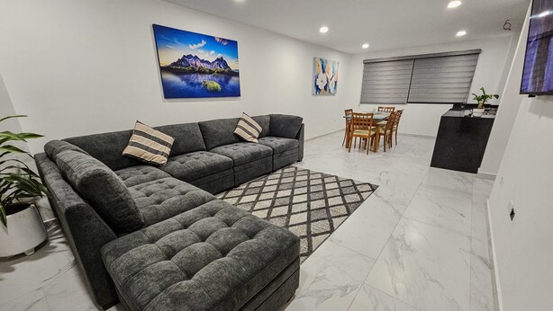 A modern living room with a sectional sofa, a dining area, and a kitchen. - Centro Expositor, Depto 2 (Heroica Puebla de Zaragoza)