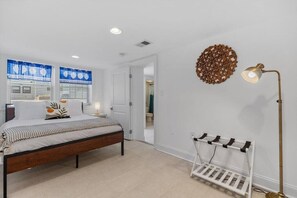 A bedroom with a bed, bedside tables, a wall-mounted lamp, and a radiator.