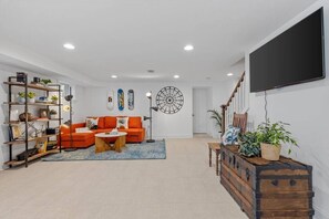 A spacious living room with a sofa, coffee table, and a bookshelf.