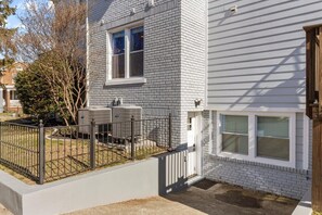 A two-story residential building with a brick facade and a white exterior.