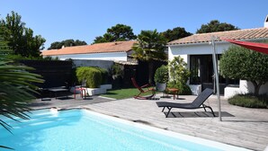 A swimming pool with lounge chairs and a wooden deck. - ALIZE              . (Rivedoux-Plage)