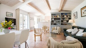Un salón amplio con comedor, un sofá y una estantería.