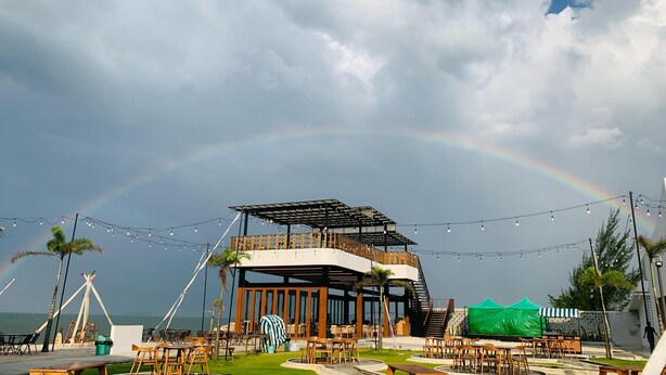 Un restaurante frente al mar con terraza, una zona cubierta y vistas al océano.