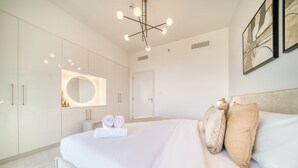 Un dormitorio moderno con una cama grande, un espejo circular y una lámpara de techo original.