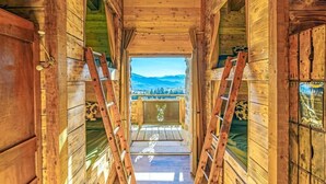 A wooden interior with a view of mountains through a window.