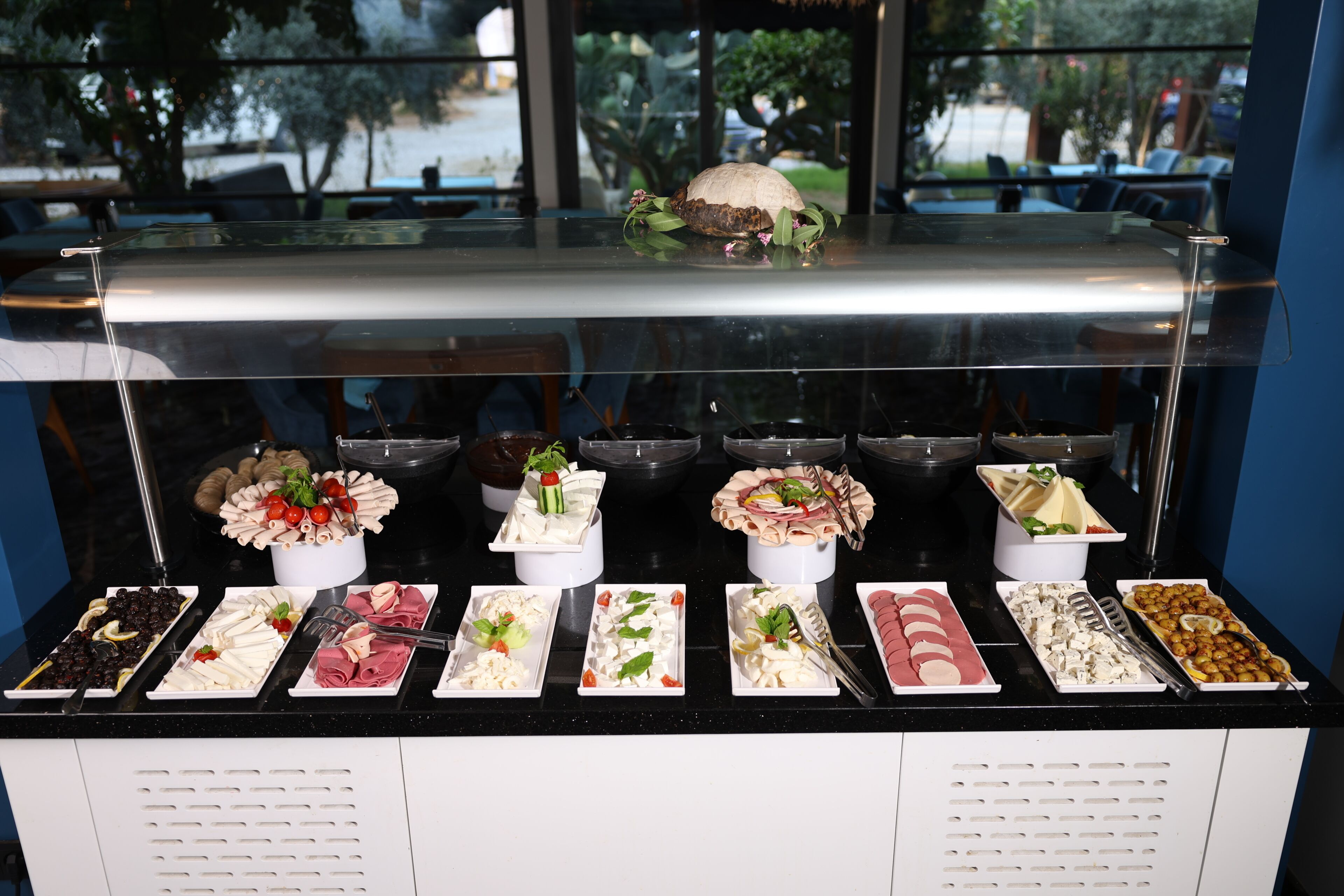 A buffet with various food items and a decorative centerpiece.
