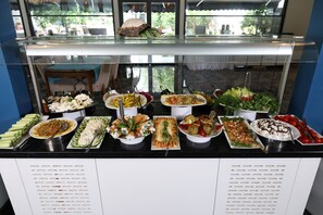 A buffet with various dishes, including salads, meats, and desserts, displayed on a counter with a glass front. - FOREST IN HOTEL (Kemer)