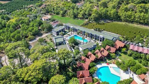 Una vista aerea di un resort con diversi edifici, una piscina e vegetazione circostante.