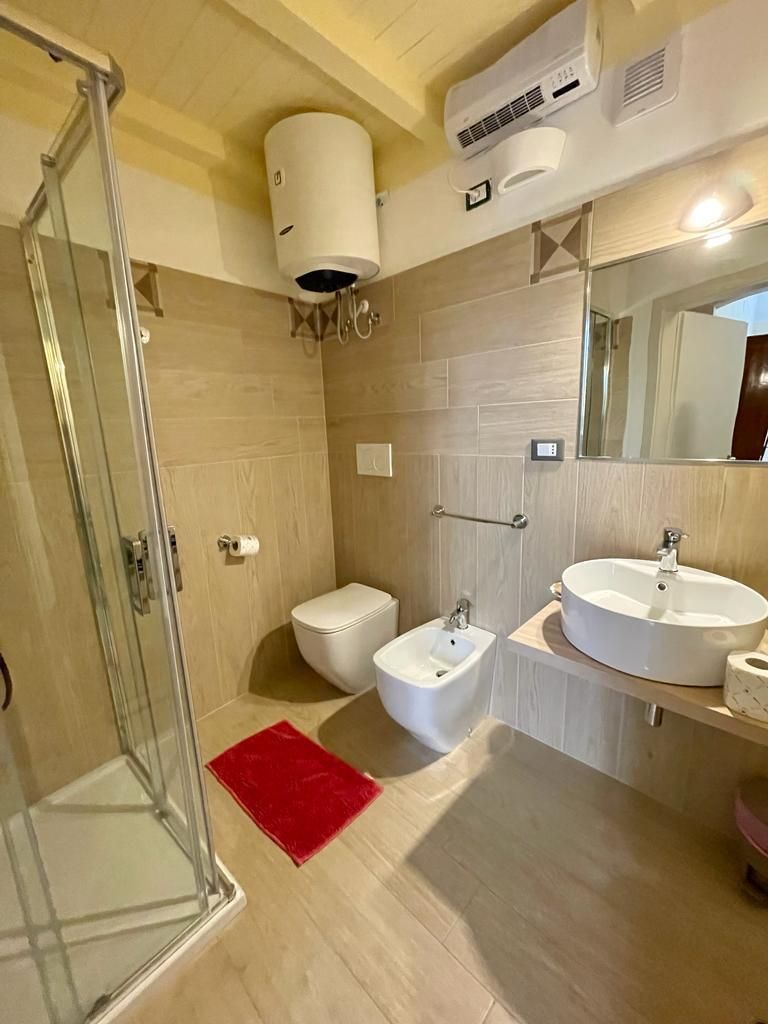 Ein Badezimmer mit Duschkabine, Toilette, Bidet und zwei Waschbecken.