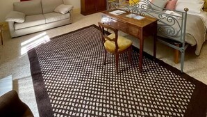 Un dormitorio con cama, escritorio, silla, sofá y armario.