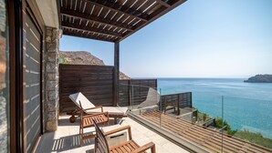 Un balcón con mobiliario de madera y vista al mar.