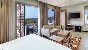 Een moderne hotelkamer met een groot bed, een bank, een televisie en een balkon met uitzicht.