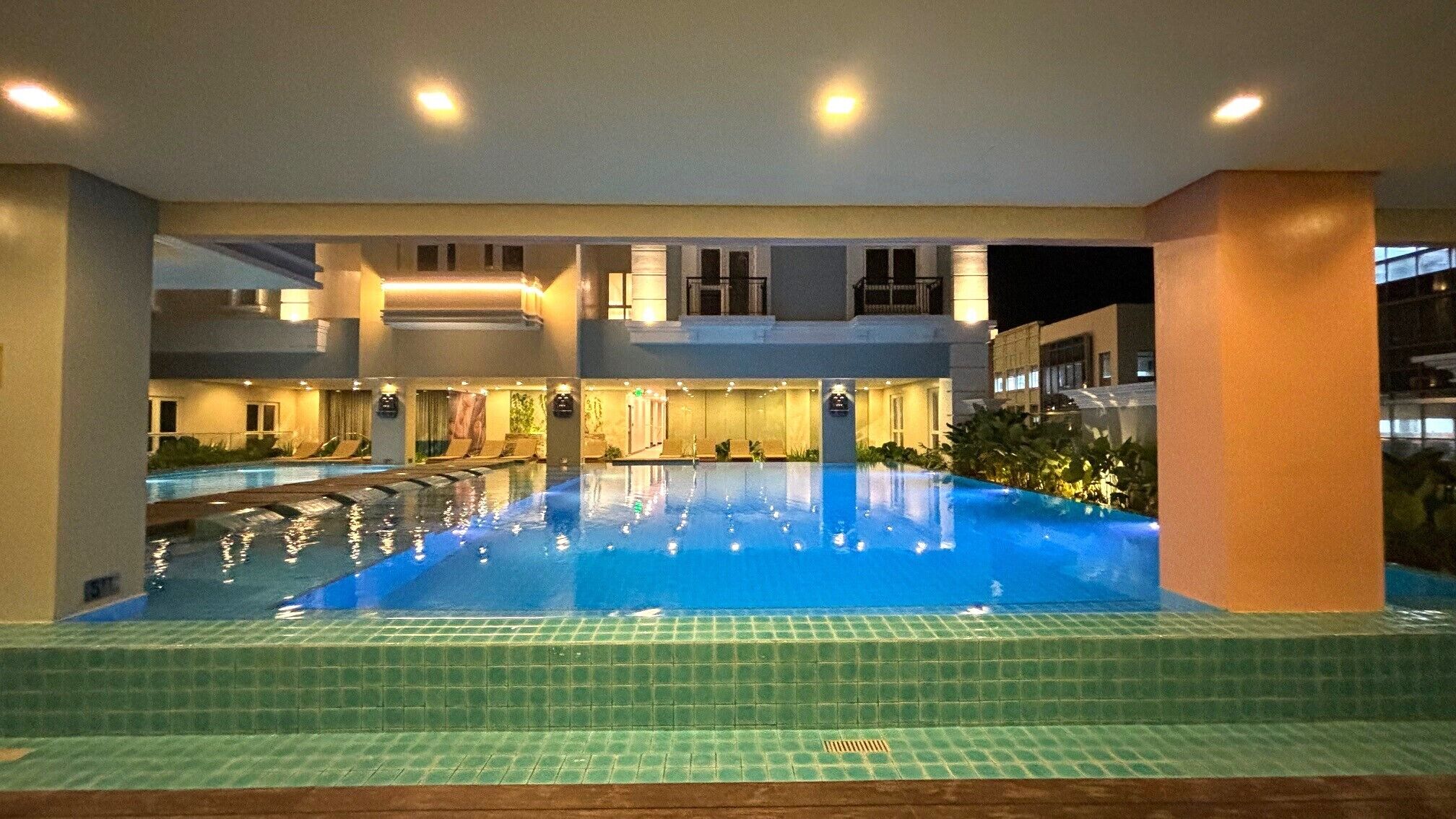 Alberca techada, alberca al aire libre y camastros