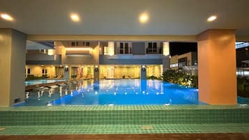 Alberca techada, alberca al aire libre y camastros