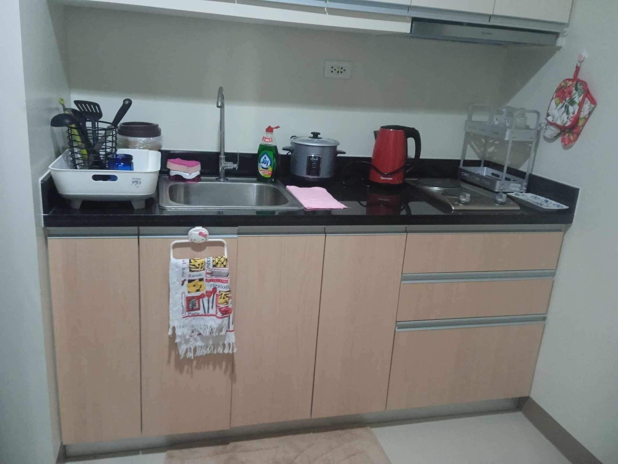 A compact kitchen with a sink, stove, and various utensils.