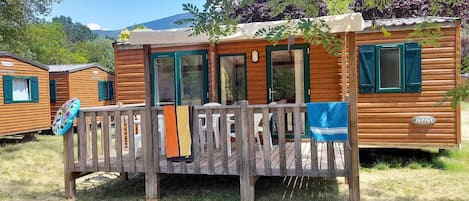 A wooden cabin with a deck, a covered porch, and a visible "IRM" logo.