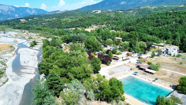 Zona residencial con piscina, rodeada de vegetación y un río.