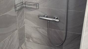 A shower with a handheld showerhead and a handheld hose.