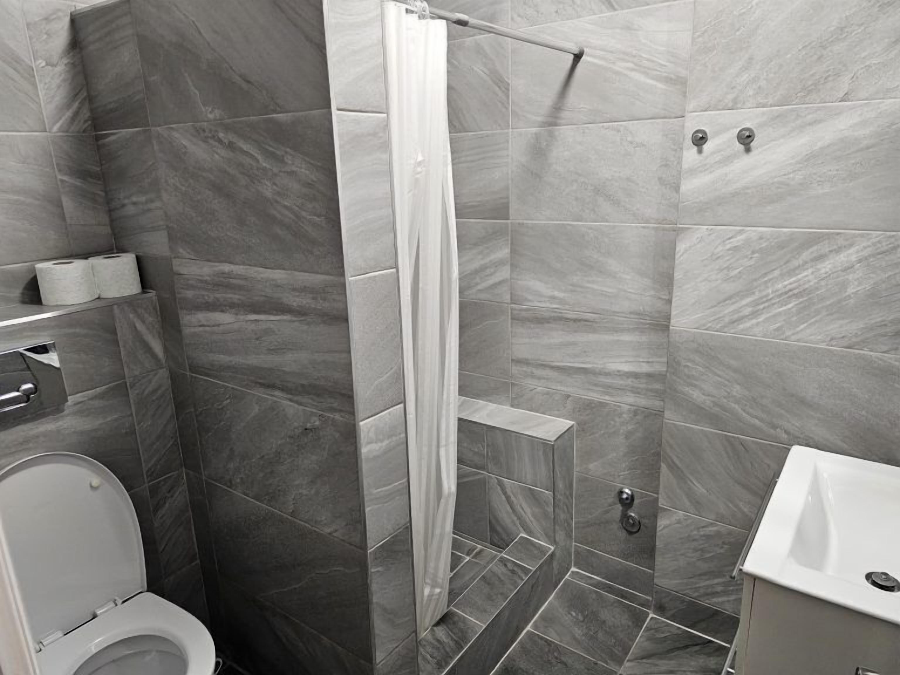 Un baño con ducha, inodoro y lavamanos.
