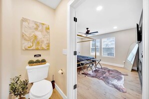 Un baño moderno con inodoro, lavamanos y un adorno en la pared.