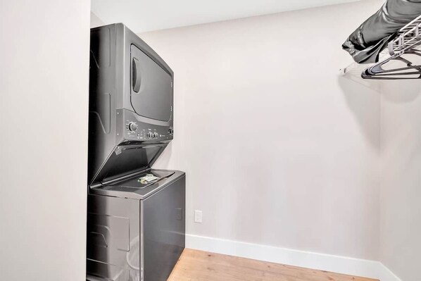 Una habitación compacta y moderna con lavadora-secadora incorporada frente a una pared lisa.