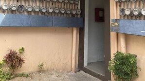 A building entrance with a covered awning, a row of parking meters, and a sign indicating 'BUILDING 3'.
