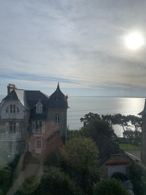 Ein Steinhaus mit einem Turm und einem Balkon, das auf ein Gewässer blickt.