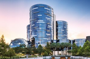 A modern building with a cylindrical design, featuring reflective glass windows and a central dome structure.