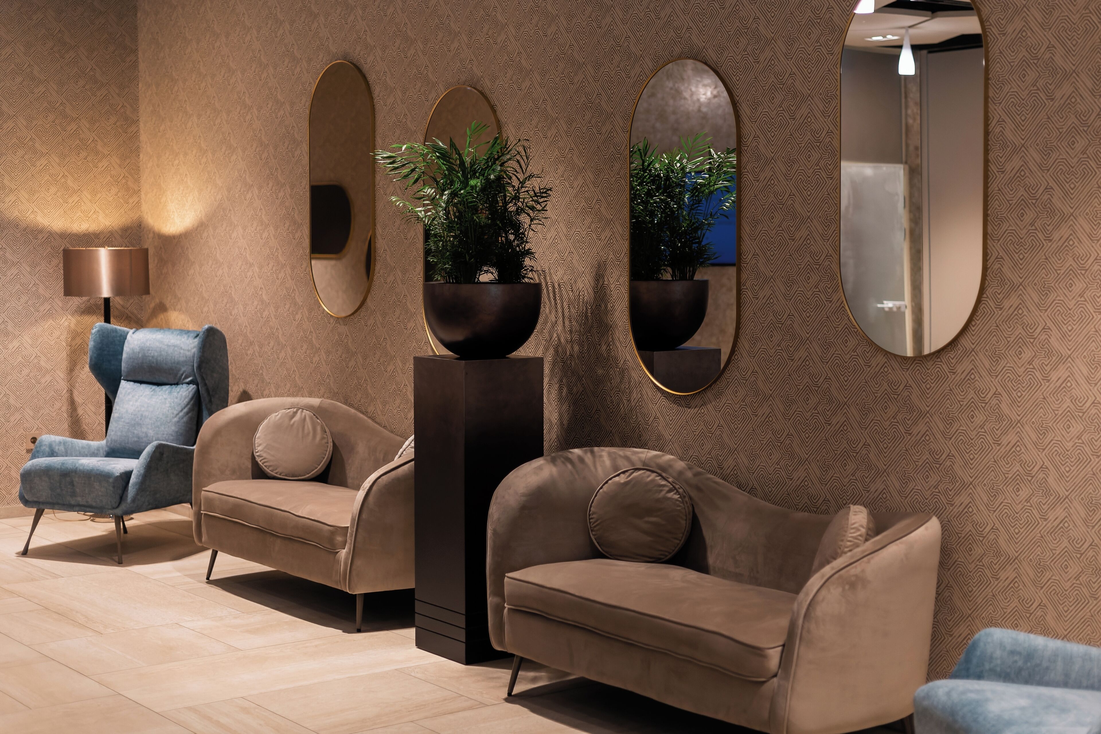 Un interior moderno con un sofá, un sillón y un espejo.