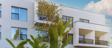 A modern multi-story building with balconies and large windows.