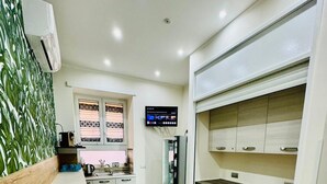 A modern kitchen with a wooden countertop, a built-in oven, and a refrigerator. - punto house ferrovia (Naples)